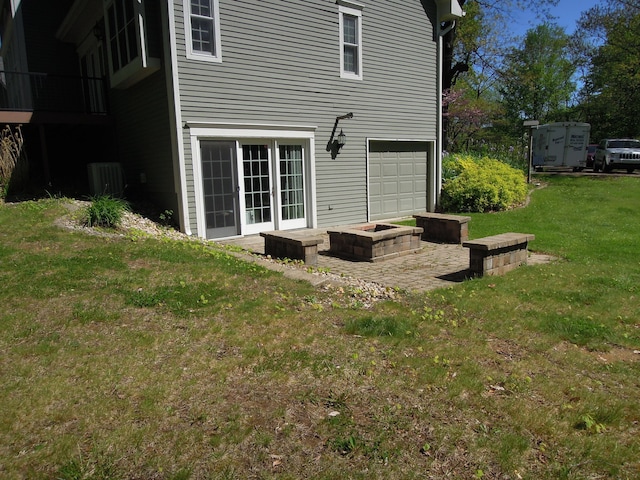 rear view of property with a lawn, a garage, and central air condition unit