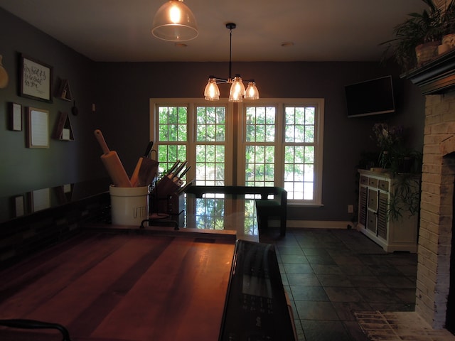 dining area featuring dark tile flooring and an inviting chandelier