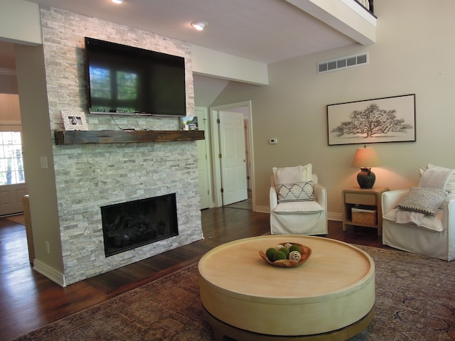 living room with dark hardwood / wood-style flooring and a fireplace