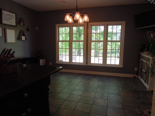 dining space featuring dark tile flooring and a chandelier