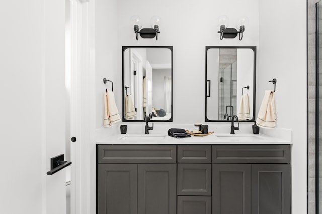 bathroom featuring dual bowl vanity and a shower with shower door