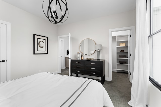 carpeted bedroom featuring an inviting chandelier, a walk in closet, and a closet