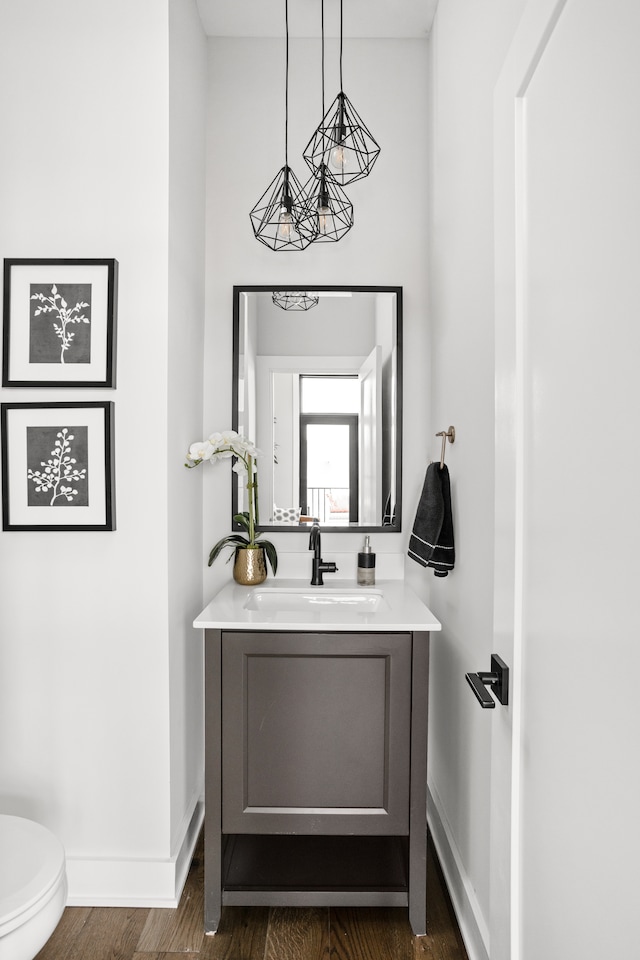 bathroom featuring wood-type flooring, vanity, and toilet