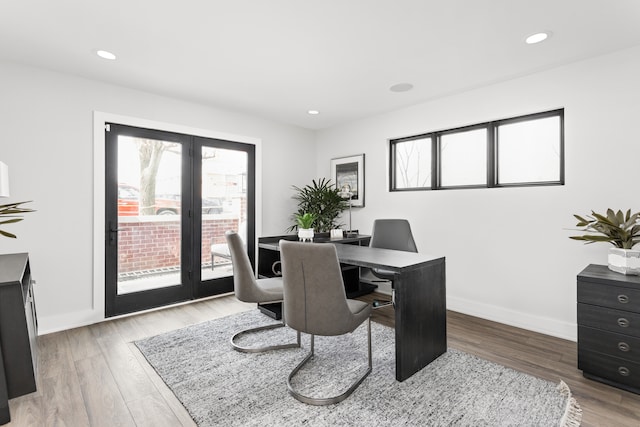 home office featuring a healthy amount of sunlight, wood-type flooring, and french doors