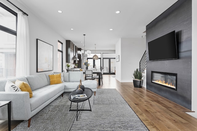 living room featuring a fireplace, hardwood / wood-style floors, and a chandelier