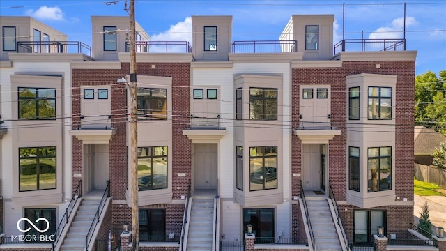 view of property featuring brick siding and stairs