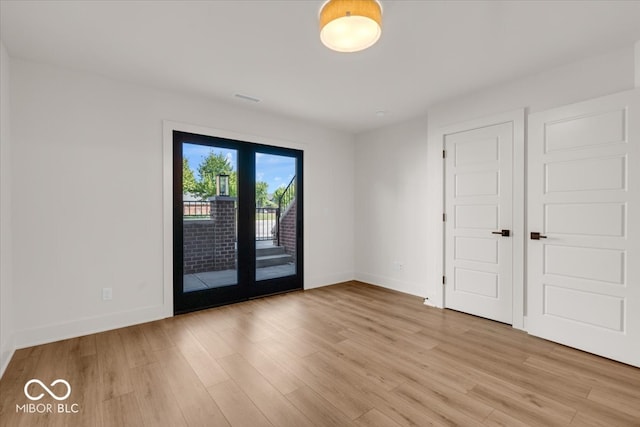 unfurnished bedroom featuring access to exterior, a closet, light wood-type flooring, and french doors