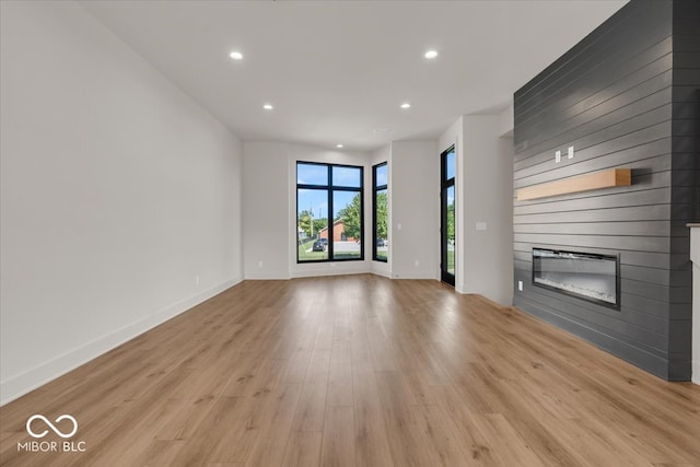 unfurnished living room with a fireplace and light wood-type flooring