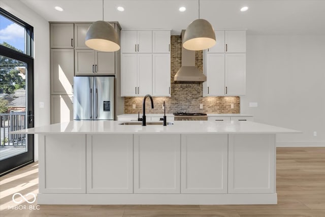 kitchen with a healthy amount of sunlight, sink, appliances with stainless steel finishes, and a kitchen island with sink