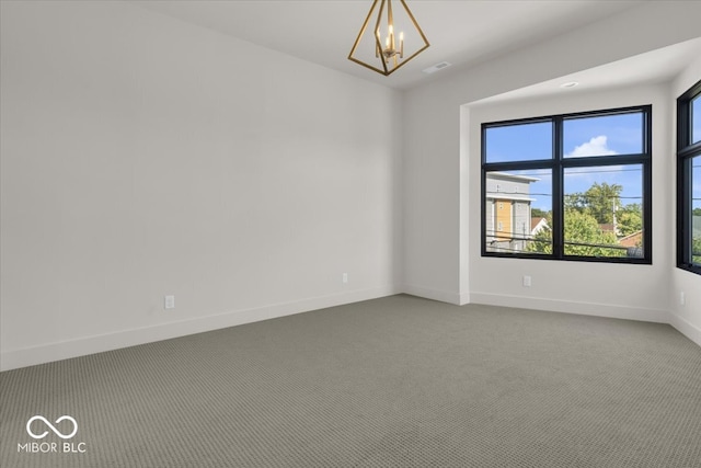 carpeted spare room featuring a chandelier