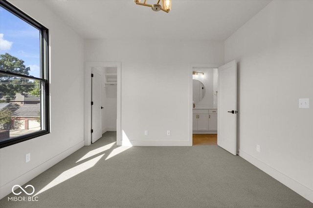 unfurnished bedroom with light colored carpet and ensuite bathroom