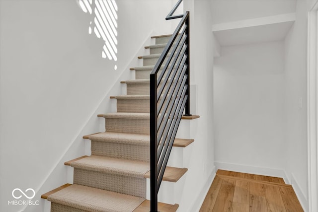 stairs featuring hardwood / wood-style floors