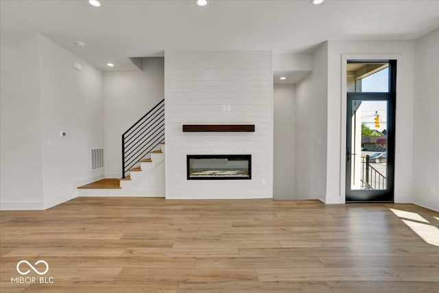 unfurnished living room featuring light wood-type flooring and a fireplace