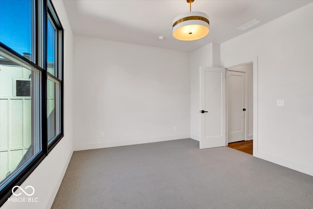 carpeted spare room featuring plenty of natural light