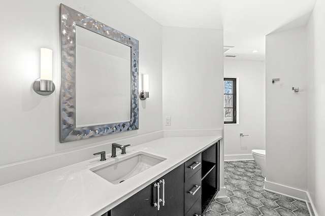 bathroom with tile flooring, vanity with extensive cabinet space, and toilet