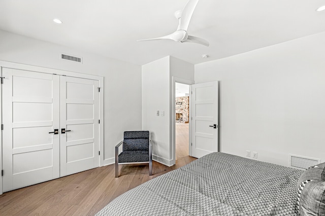 bedroom with ceiling fan, a closet, and light hardwood / wood-style flooring