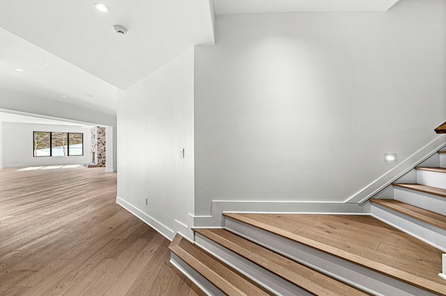 staircase with vaulted ceiling and light wood-type flooring