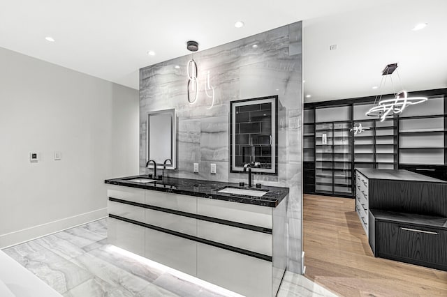 kitchen featuring light hardwood / wood-style flooring, sink, and decorative light fixtures