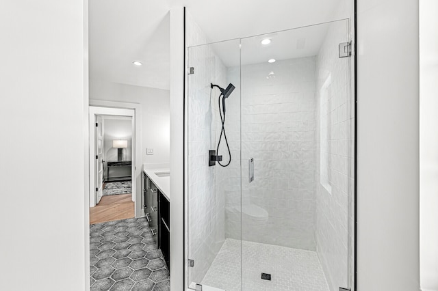 bathroom with tile floors, vanity, and a shower with door