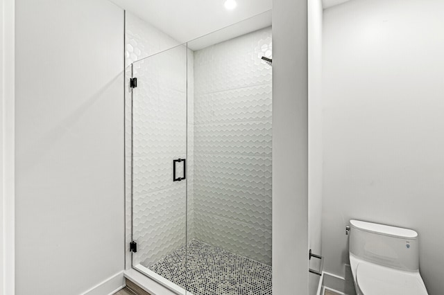 bathroom featuring walk in shower and toilet