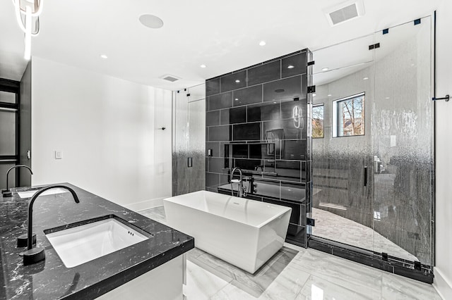 bathroom featuring double sink, a shower with shower door, and tile flooring