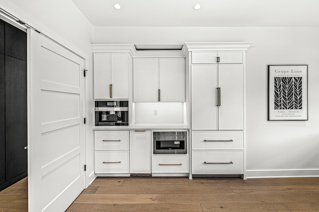 kitchen with stainless steel oven, white cabinetry, and dark hardwood / wood-style floors