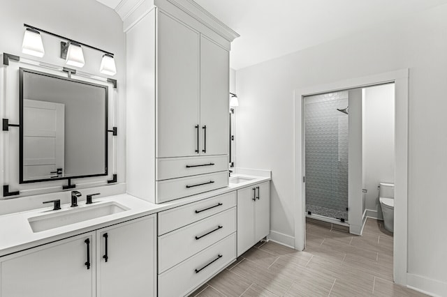 bathroom featuring toilet, double vanity, tile flooring, and a tile shower