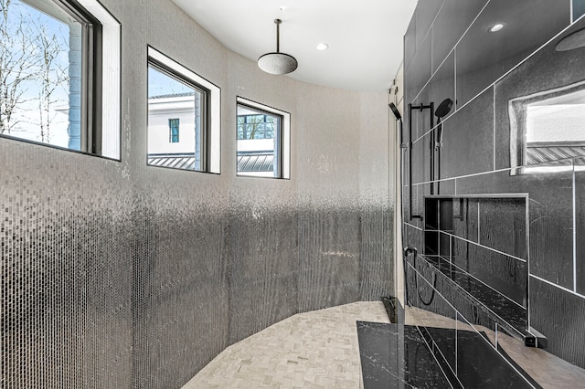 bathroom featuring tile walls and tiled shower