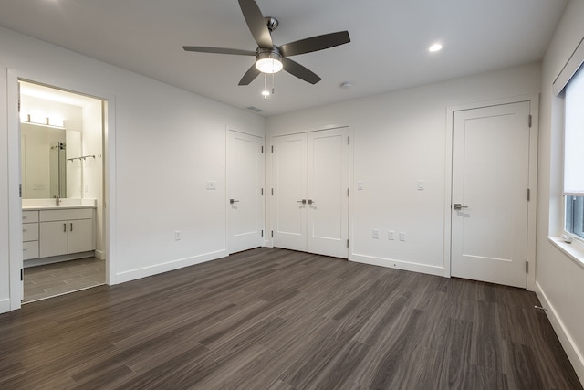 unfurnished bedroom with dark hardwood / wood-style floors, ceiling fan, ensuite bathroom, and sink