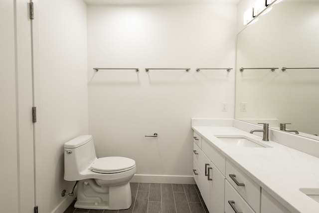 bathroom with toilet, tile floors, and vanity