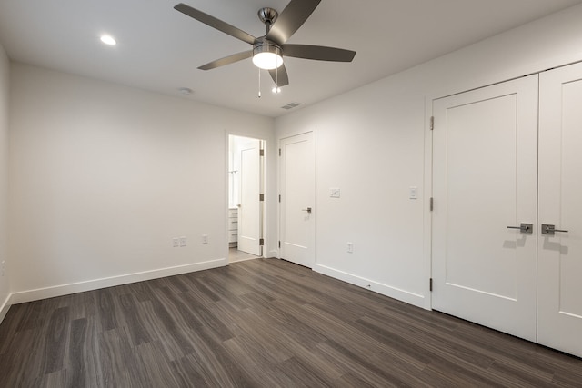 unfurnished bedroom with ceiling fan, a closet, and dark wood-type flooring