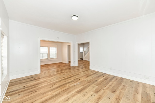 spare room featuring crown molding and light hardwood / wood-style flooring