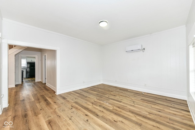 unfurnished room with hardwood / wood-style floors, a wall mounted air conditioner, and ornamental molding