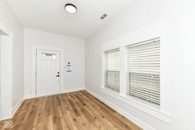 foyer entrance featuring hardwood / wood-style flooring and crown molding