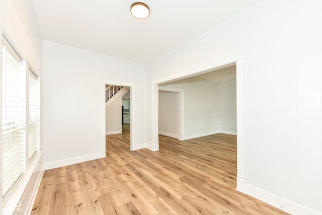 spare room featuring light hardwood / wood-style floors and crown molding