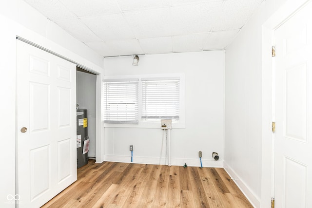 laundry room with hardwood / wood-style floors and electric water heater