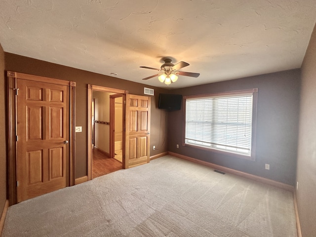 unfurnished bedroom featuring ceiling fan and carpet