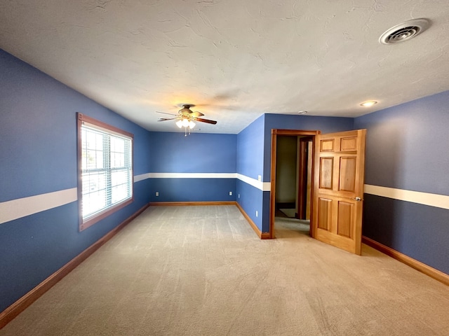 carpeted spare room featuring ceiling fan