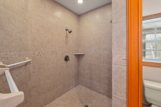 bathroom with toilet and a tile shower