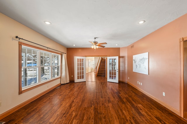 empty room with ceiling fan, french doors, and dark hardwood / wood-style floors