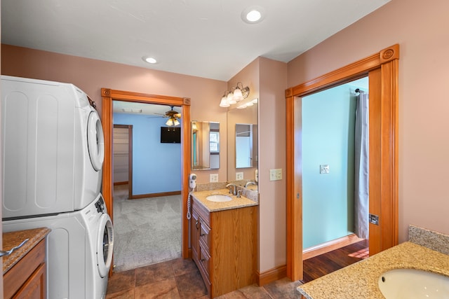 bathroom with stacked washer and dryer, ceiling fan, vanity, and tile flooring