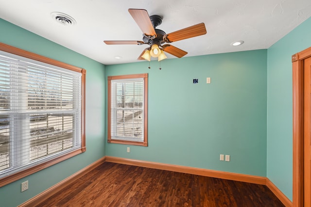 unfurnished room with ceiling fan and dark wood-type flooring