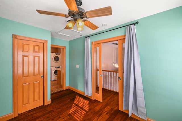 interior space with stacked washer / drying machine and dark wood-type flooring