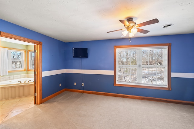 carpeted spare room featuring ceiling fan