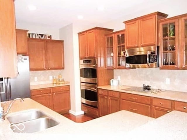 kitchen with stainless steel appliances, sink, and backsplash