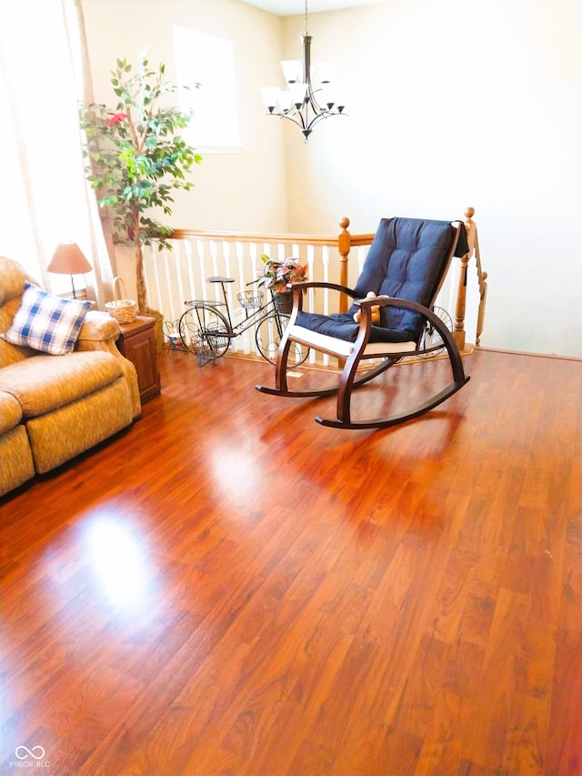 sitting room with hardwood / wood-style floors and a chandelier