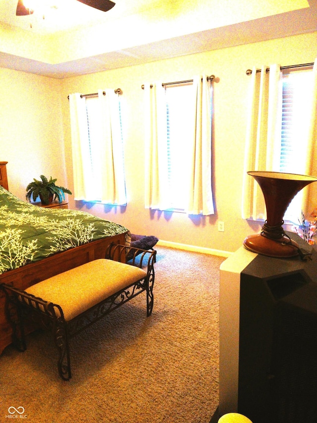 carpeted bedroom featuring multiple windows and ceiling fan