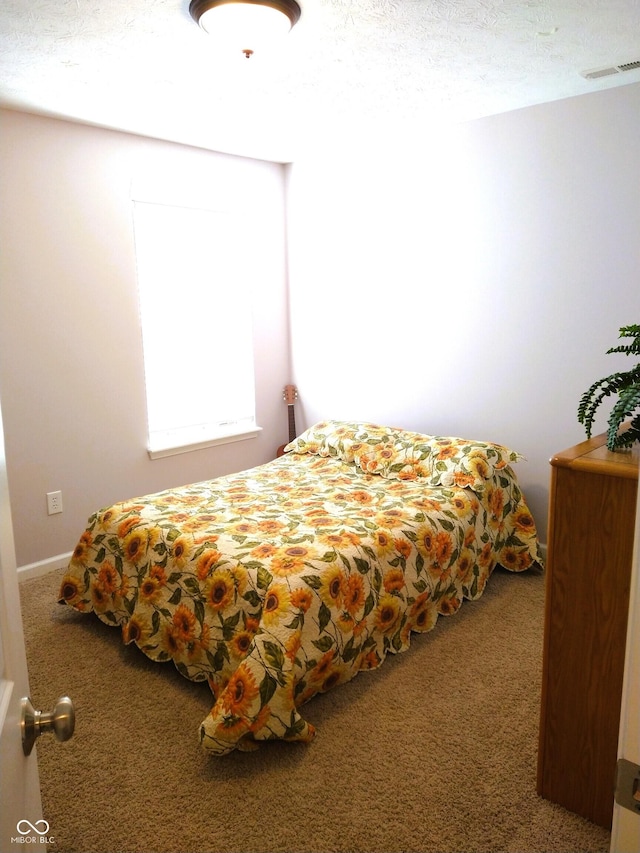 carpeted bedroom featuring a textured ceiling