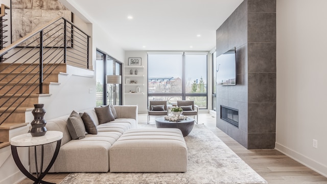 living room featuring light hardwood / wood-style floors and a tiled fireplace