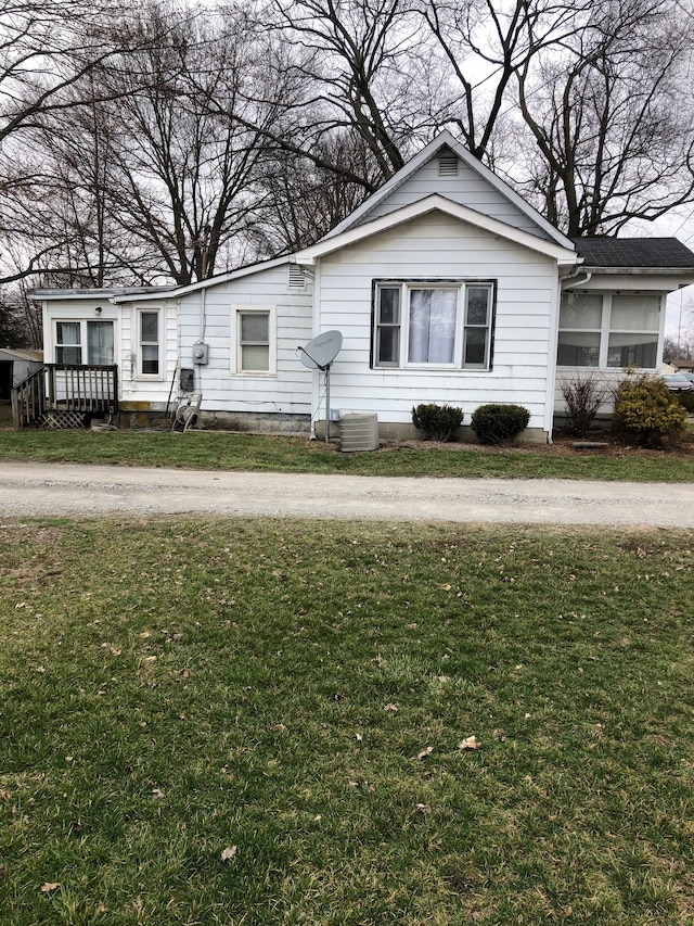 view of front of home featuring central AC and a front lawn